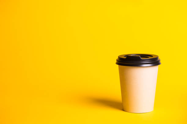 istock coffee to go. paper cup with coffee on a yellow background.