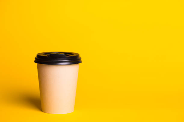 istock coffee to go. paper cup with coffee on a yellow background.