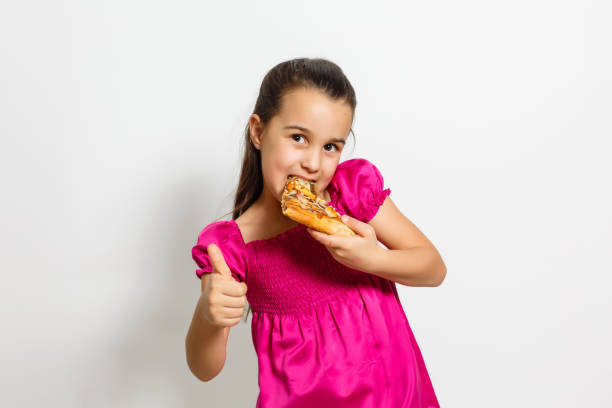 istock happy little girl with pizza white background 1212252724