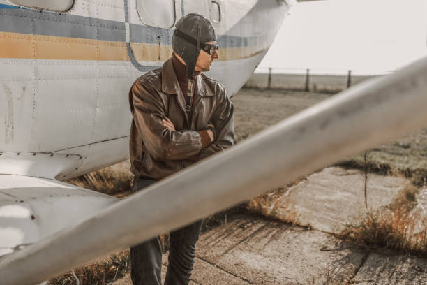 istock Confident man in aviator hat staying near plane 1212252852