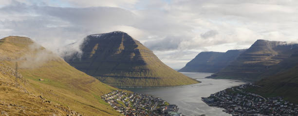 Klakkur and Suður á Nakki Mountain Peaks rising out of the Sea next to remote Klaksvík village in Northern Faroe Islands, Denmark. stock photo