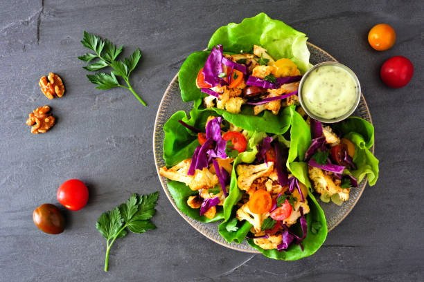 здоровый растительный салат обертывания с жареной цветной капустой, вид сверху на темном фоне шифера - sandwich healthy eating wrap sandwich food стоковые фото и изображения