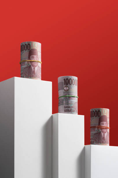индонезийская рупия катится на красном фоне - photography still life vertical bill стоковые фото и изображения