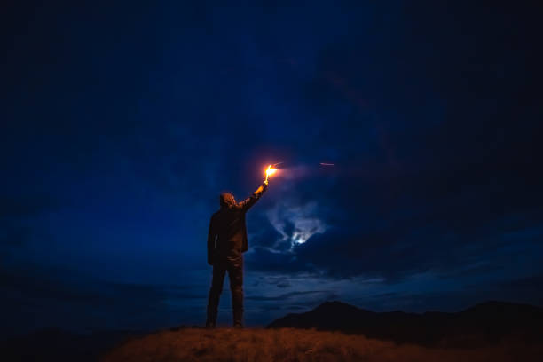 istock The male with a firework stick standing on a mountain. evening night time 1212259194