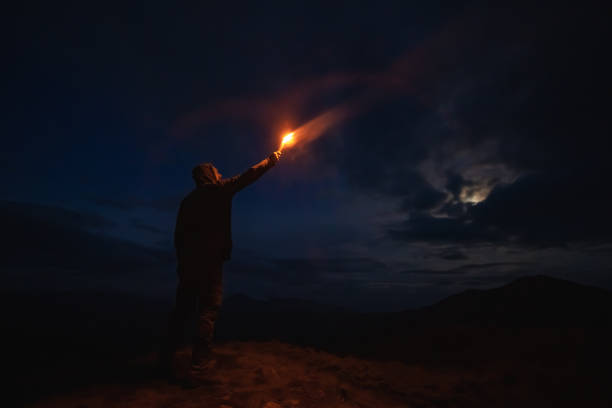 istock The male with a firework stick standing on the night mountain 1212259199