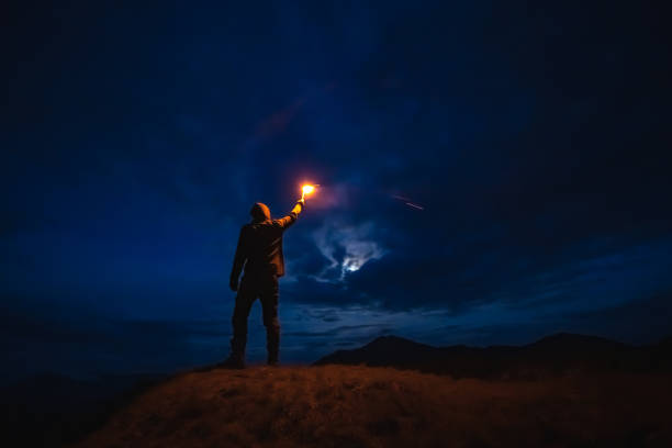 istock The male with a firework stick standing on a mountain. evening night time 1212259217