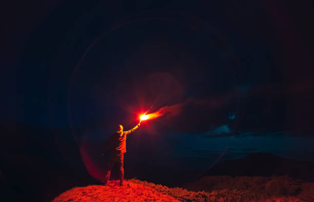 istock The man with a red firework stick standing on a night mountain 1212259230