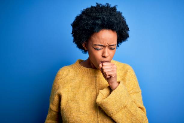 junge schöne afroamerikanische afro-frau mit lockigen haaren trägt gelben lässigen pullover gefühl unwohl und husten als symptom für erkältung oder bronchitis. gesundheitskonzept. - husten stock-fotos und bilder