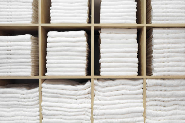 istock Fresh White Hotel Towels Folded and Stacked on a Shelf 1212263265