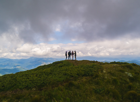 The four people standing on a mountain against the picturesque cloudscape