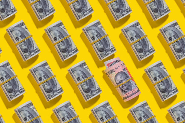 istock Indian rupee and American dollar rolls on yellow background 1212263727