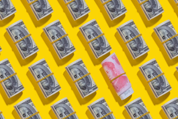 istock Chinese yuan and American dollar rolls on yellow background 1212265195