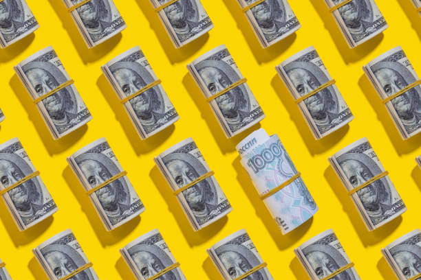 istock Russian roubles and American dollar rolls on yellow background 1212265390