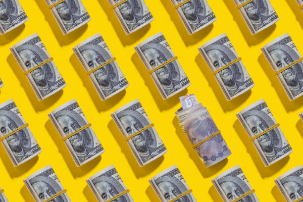 istock Argentine peso and American dollar rolls on yellow background 1212265594