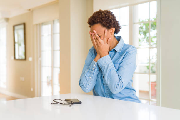 istock Young beautiful african american woman with sad expression covering face with hands while crying. Depression concept. 1212265700