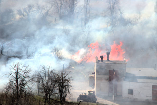 istock Farm fire. Burning building and agricultural machinery. 1212267323