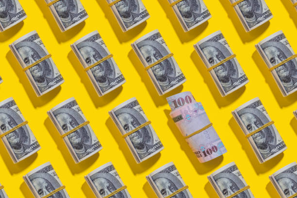 istock Saudi riyal and American dollar rolls on yellow background 1212267548