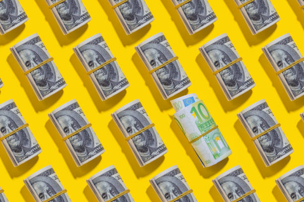 istock Euro and American dollar rolls on yellow background 1212267698