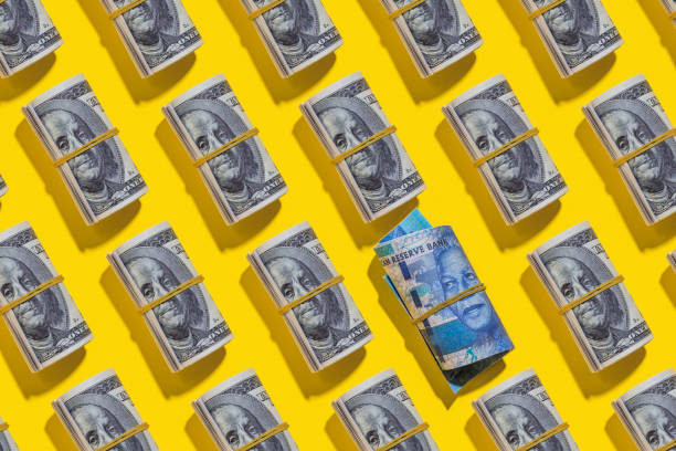istock South African rand and American dollar rolls on yellow background 1212267826