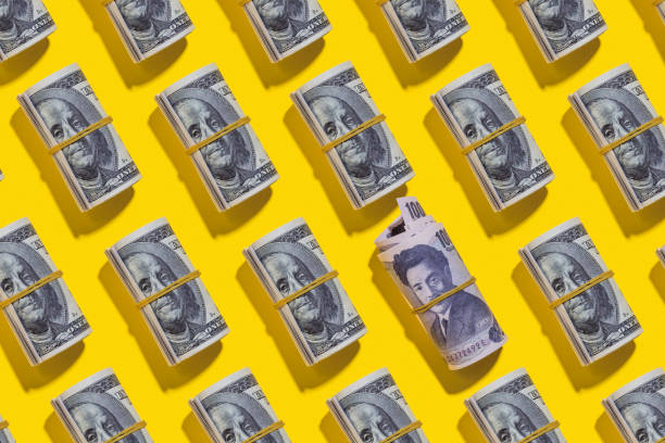 istock Japanese yen and American dollar rolls on yellow background 1212268608