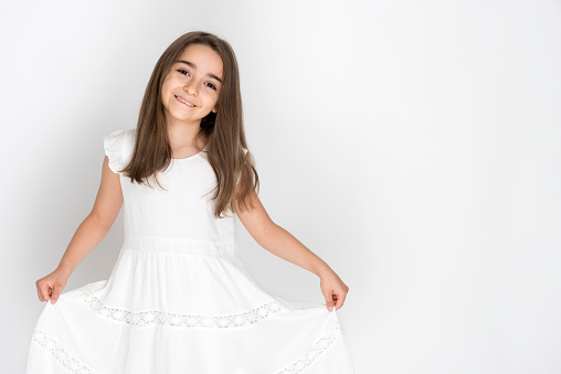 Cute little girl in white dress smiling on camera