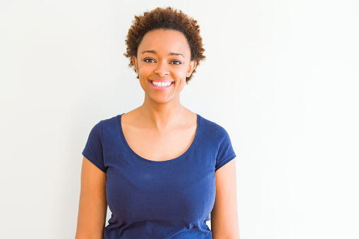 Young beautiful african american woman over white background with a happy and cool smile on face. Lucky person.