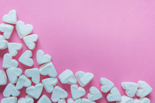 istock Heart shaped marshmallows on pink background 1212271461