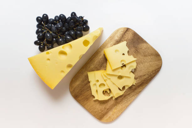 istock Maasdam cheese on wooden board with blue grapes 1212271519
