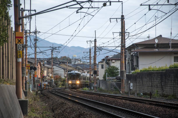Kyoto, Japan-26 Nov, 2019: Sagano local train pass through Arashiyama in the autumn. Sagano Line is the popular name for a portion of the Sanin Main Line in the suburbs of Kyoto