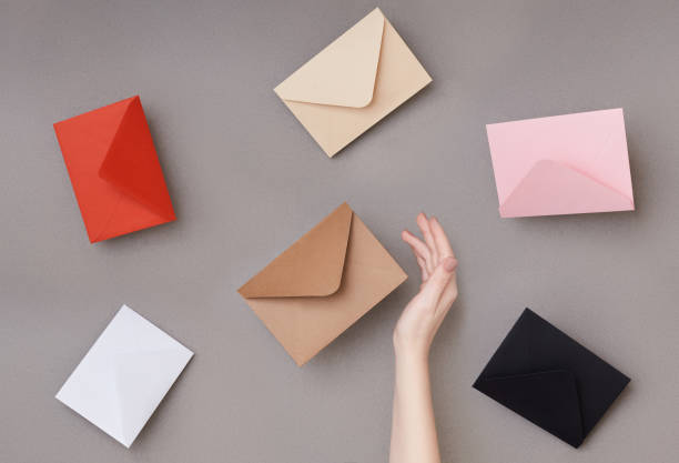 istock Composition of many envelopes in different colors and woman's hand. Mail concept 1212275796