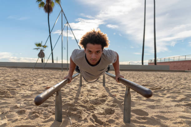 istock The young Latino man doing push-up exercise on the bars 1212276679