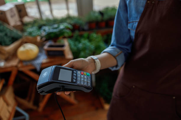 istock Female holding a payment terminal in her hand 1212279567