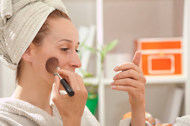 istock woman in bathrobe applying make up 121228082