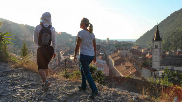 istock Mother and daughter hike up cobble stone path at sunrise 1212281843