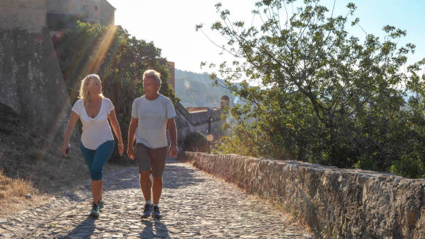 Mature couple hike up cobble stone path at sunrise