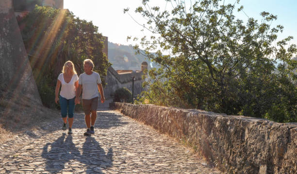 istock Mature couple hike up cobble stone path at sunrise 1212281874