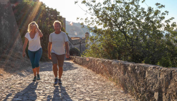 istock Mature couple hike up cobble stone path at sunrise 1212281886