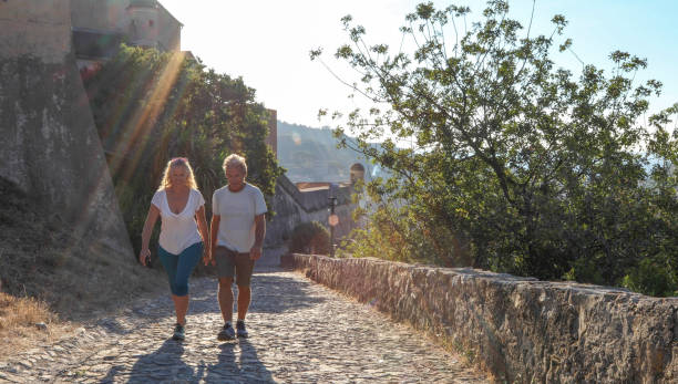 istock Mature couple hike up cobble stone path at sunrise 1212281887