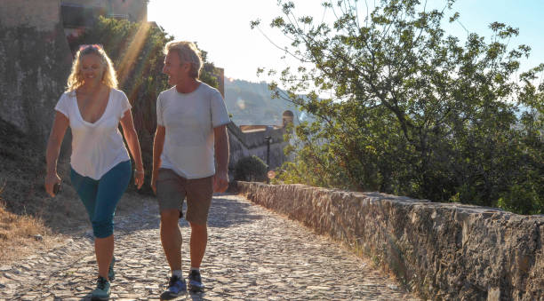 istock Mature couple hike up cobble stone path at sunrise 1212281900