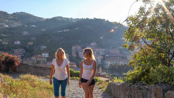 istock Mother and daughter hike up cobble stone path at sunrise 1212281906
