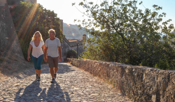 istock Mature couple hike up cobble stone path at sunrise 1212281913