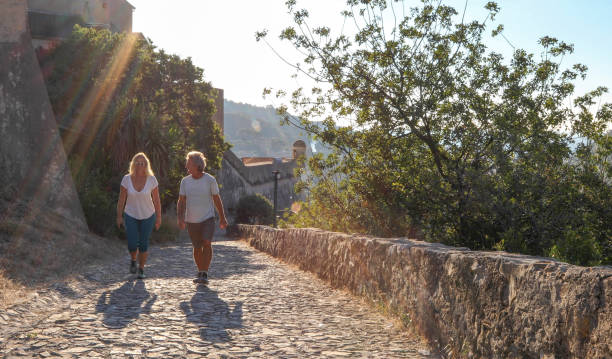 istock Mature couple hike up cobble stone path at sunrise 1212282431