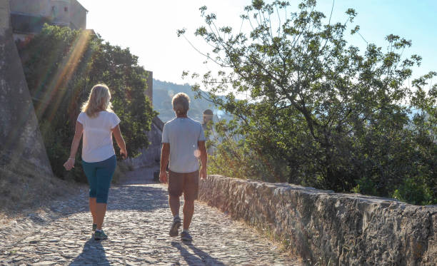 istock Mature couple hike up cobble stone path at sunrise 1212282440