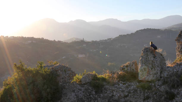istock Female trail runner scrambles up boulder at sunrise 1212282615