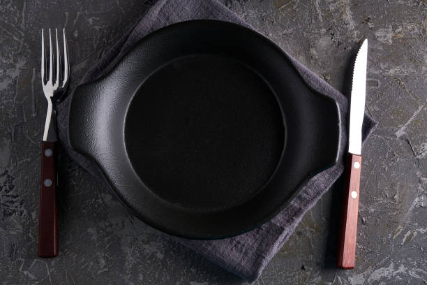 istock Black dishes with fork and knife on a gray background Vertcal Copy space 1212301765
