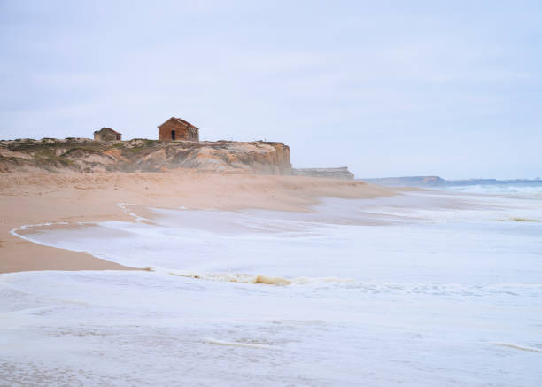 old house over the cliff at beach on a cloudy day