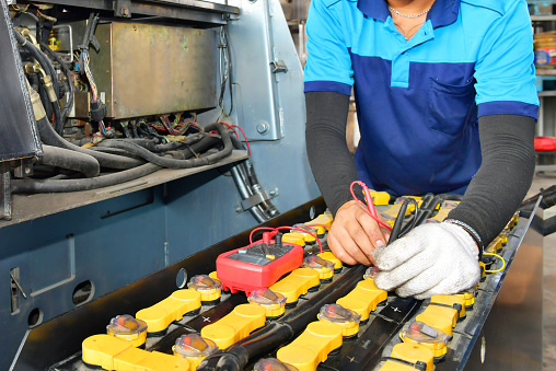 Technician inspection holding Battery Capacity Tester Voltmeter .for service maintenance of industrial to engine repair