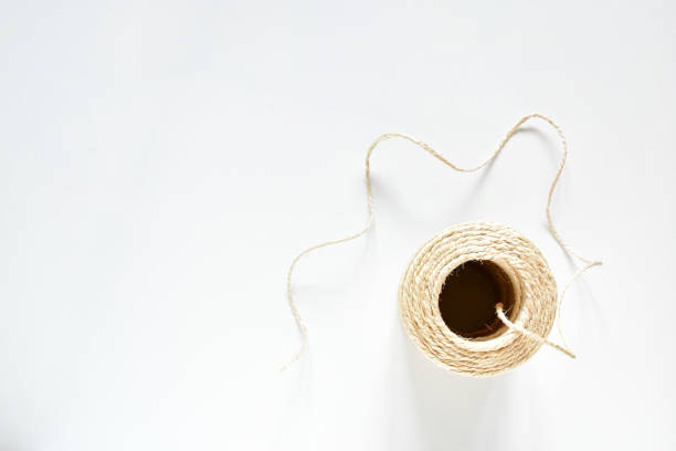 Linen roll yellow white string object on white background, Natural Brown Shabby Style Rustic String Twine Shank Craft ,string use for tight things together and creative idea for hobby.  top view. stock photo