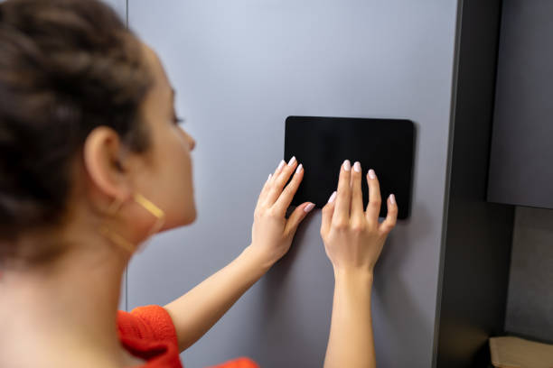 istock Woman hands holding tablet against grey wall 1212309973