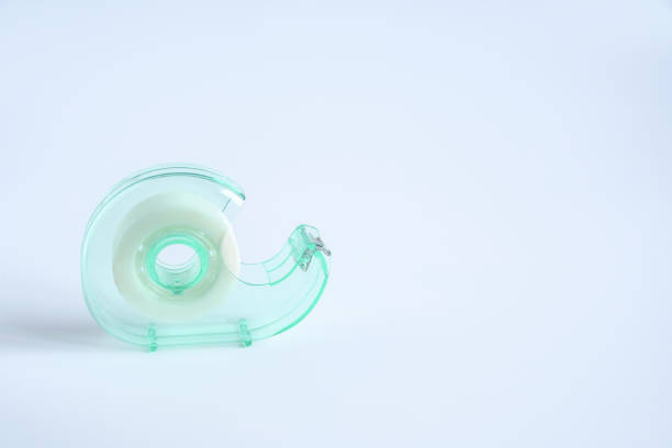 istock Green transparent plastic tape dispenser with tape on white background with space for text.  Object help wrapping things for use in office or education concept. 1212310050